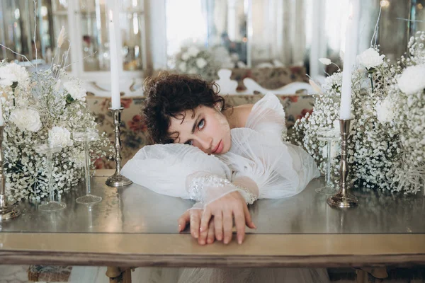 Güzel kıvırcık saçlı gelin lüks bir gelinlik içinde düğün dekorlu bir restoranda