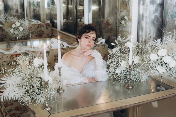 Güzel kıvırcık saçlı gelin lüks bir gelinlik içinde düğün dekorlu bir restoranda