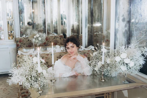 Güzel kıvırcık saçlı gelin lüks bir gelinlik içinde düğün dekorlu bir restoranda