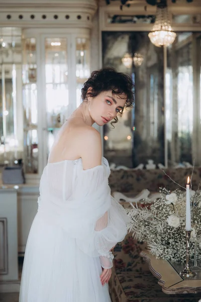 Güzel kıvırcık saçlı gelin lüks bir gelinlik içinde düğün dekorlu bir restoranda