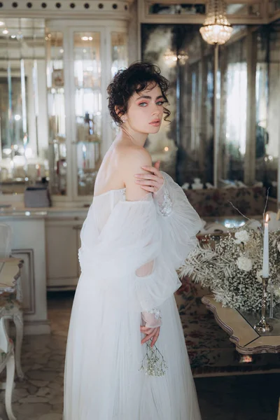 Güzel kıvırcık saçlı gelin lüks bir gelinlik içinde düğün dekorlu bir restoranda