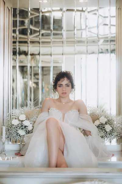 Güzel kıvırcık saçlı gelin lüks bir gelinlik içinde düğün dekorlu bir restoranda