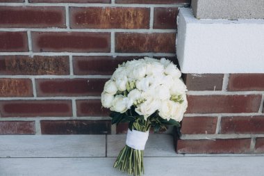 Gelinin elinde gelinlik içinde lüks bir buket.