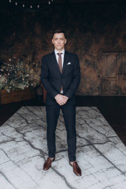 Şık bir damat sabahı, siyah bir takım elbise ve kravatla, oteldeki hazırlıkları, bir fotoğraf stüdyosunda, düğmeler ve ceketler, portreler.