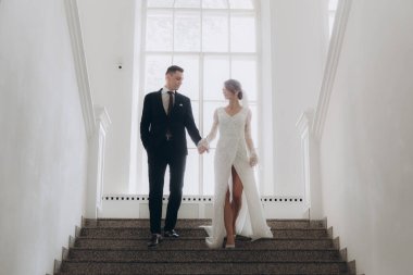 Güzel, şık bir çiftin düğünü, beyaz gelinlikli bir gelin ve siyah takım elbiseli bir damat,.