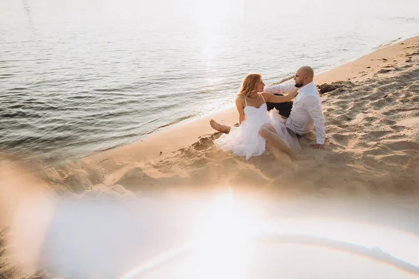 Güzel bir çiftin gün batımında düğün fotoğrafları, beyaz elbiseli gelin, beyaz gömlekli ve siyah pantolonlu damat.