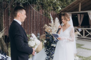 Şık bir çiftin yaz aylarında güzel bir uzay nikahı, takım elbiseli bir damat ve beyaz bir gelinlik içinde gelin..