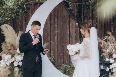 Şık bir çiftin yaz aylarında güzel bir uzay nikahı, takım elbiseli bir damat ve beyaz bir gelinlik içinde gelin..