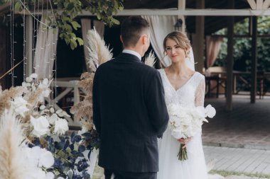 Şık bir çiftin yaz aylarında güzel bir uzay nikahı, takım elbiseli bir damat ve beyaz bir gelinlik içinde gelin..