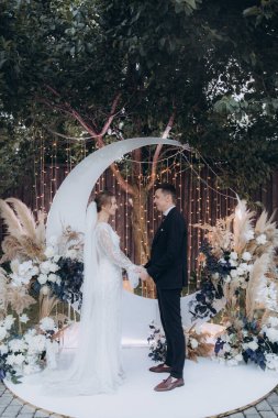 Şık bir çiftin yaz aylarında güzel bir uzay nikahı, takım elbiseli bir damat ve beyaz bir gelinlik içinde gelin..