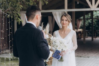 Şık bir çiftin yaz aylarında güzel bir uzay nikahı, takım elbiseli bir damat ve beyaz bir gelinlik içinde gelin..