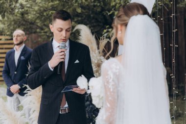 Şık bir çiftin yaz aylarında güzel bir uzay nikahı, takım elbiseli bir damat ve beyaz bir gelinlik içinde gelin..