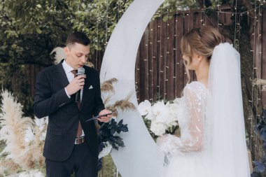 Şık bir çiftin yaz aylarında güzel bir uzay nikahı, takım elbiseli bir damat ve beyaz bir gelinlik içinde gelin..