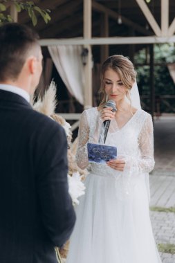 Şık bir çiftin yaz aylarında güzel bir uzay nikahı, takım elbiseli bir damat ve beyaz bir gelinlik içinde gelin..