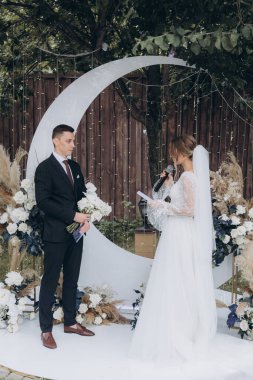 Şık bir çiftin yaz aylarında güzel bir uzay nikahı, takım elbiseli bir damat ve beyaz bir gelinlik içinde gelin..