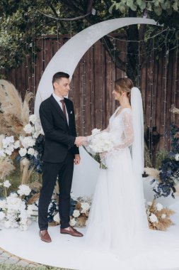 Şık bir çiftin yaz aylarında güzel bir uzay nikahı, takım elbiseli bir damat ve beyaz bir gelinlik içinde gelin..