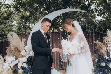 Şık bir çiftin yaz aylarında güzel bir uzay nikahı, takım elbiseli bir damat ve beyaz bir gelinlik içinde gelin..