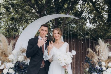 Şık bir çiftin yaz aylarında güzel bir uzay nikahı, takım elbiseli bir damat ve beyaz bir gelinlik içinde gelin..