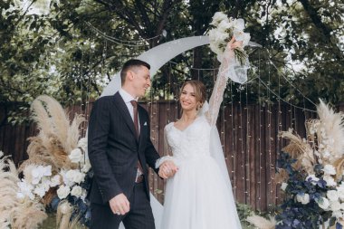 Şık bir çiftin yaz aylarında güzel bir uzay nikahı, takım elbiseli bir damat ve beyaz bir gelinlik içinde gelin..