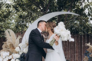 Şık bir çiftin yaz aylarında güzel bir uzay nikahı, takım elbiseli bir damat ve beyaz bir gelinlik içinde gelin..