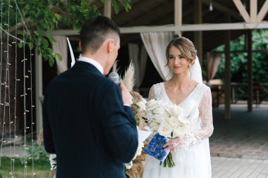 Şık bir çiftin yaz aylarında güzel bir uzay nikahı, takım elbiseli bir damat ve beyaz bir gelinlik içinde gelin..