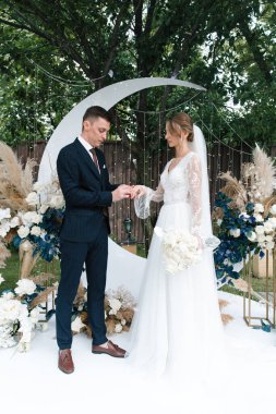 Şık bir çiftin yaz aylarında güzel bir uzay nikahı, takım elbiseli bir damat ve beyaz bir gelinlik içinde gelin..