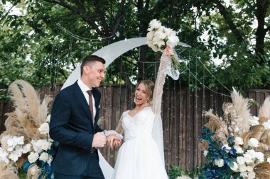 Şık bir çiftin yaz aylarında güzel bir uzay nikahı, takım elbiseli bir damat ve beyaz bir gelinlik içinde gelin..