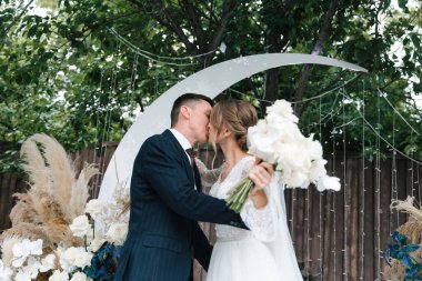 Şık bir çiftin yaz aylarında güzel bir uzay nikahı, takım elbiseli bir damat ve beyaz bir gelinlik içinde gelin..