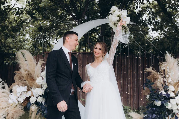 Şık bir çiftin yaz aylarında güzel bir uzay nikahı, takım elbiseli bir damat ve beyaz bir gelinlik içinde gelin..