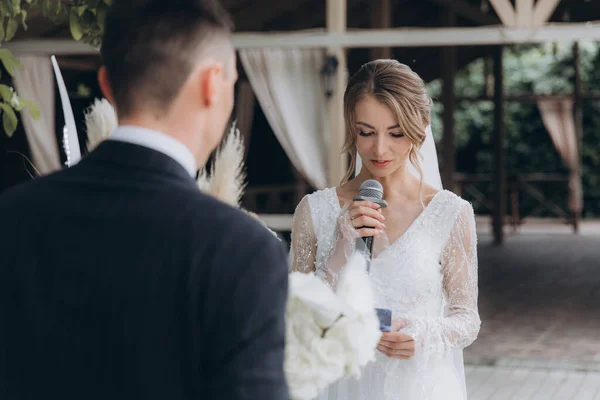 Şık bir çiftin yaz aylarında güzel bir uzay nikahı, takım elbiseli bir damat ve beyaz bir gelinlik içinde gelin..