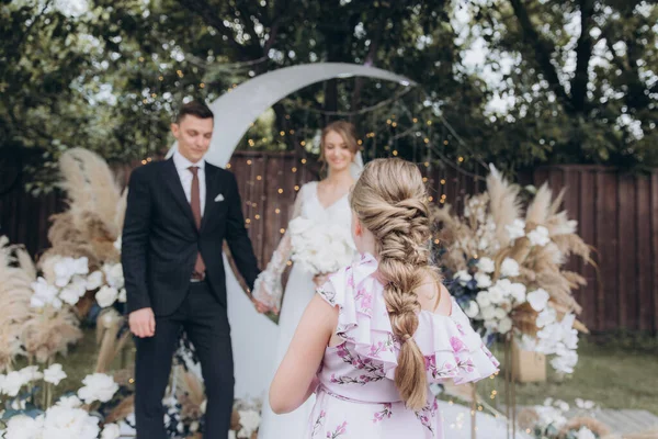 Şık bir çiftin yaz aylarında güzel bir uzay nikahı, takım elbiseli bir damat ve beyaz bir gelinlik içinde gelin..