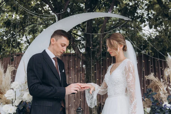 Şık bir çiftin yaz aylarında güzel bir uzay nikahı, takım elbiseli bir damat ve beyaz bir gelinlik içinde gelin..