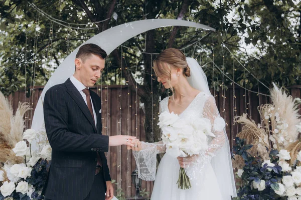 Şık bir çiftin yaz aylarında güzel bir uzay nikahı, takım elbiseli bir damat ve beyaz bir gelinlik içinde gelin..