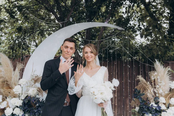 Şık bir çiftin yaz aylarında güzel bir uzay nikahı, takım elbiseli bir damat ve beyaz bir gelinlik içinde gelin..