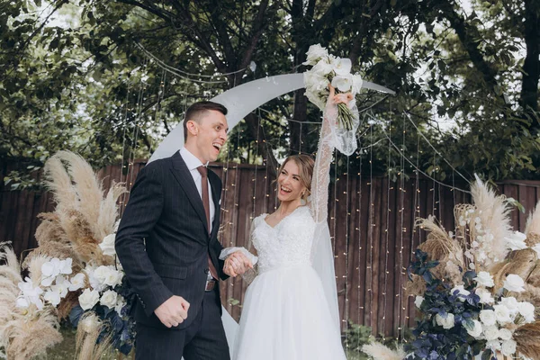 Şık bir çiftin yaz aylarında güzel bir uzay nikahı, takım elbiseli bir damat ve beyaz bir gelinlik içinde gelin..