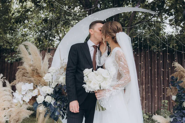 Şık bir çiftin yaz aylarında güzel bir uzay nikahı, takım elbiseli bir damat ve beyaz bir gelinlik içinde gelin..