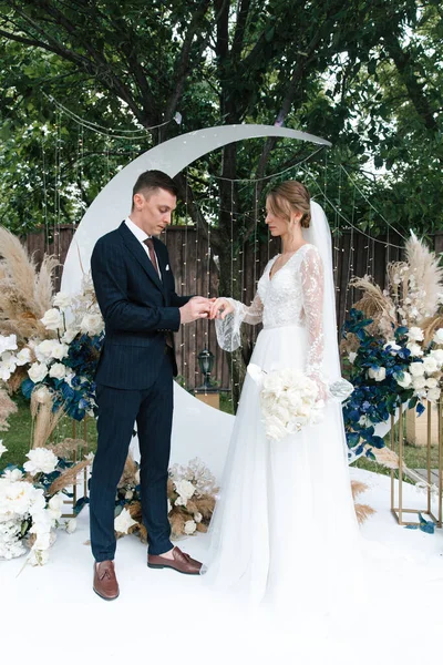 Şık bir çiftin yaz aylarında güzel bir uzay nikahı, takım elbiseli bir damat ve beyaz bir gelinlik içinde gelin..