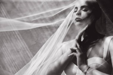 Bald beautiful bride in a luxurious wedding dress in red lipstick and a long veil is sick with cancer