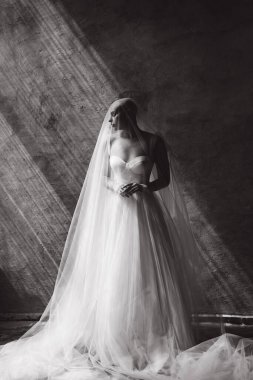 Bald beautiful bride in a luxurious wedding dress in red lipstick and a long veil is sick with cancer