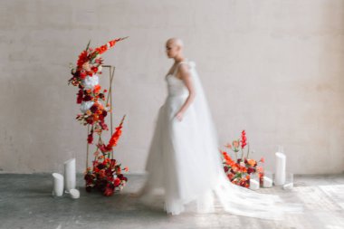 Bald beautiful bride in a luxurious wedding dress in red lipstick and a long veil is sick with cancer