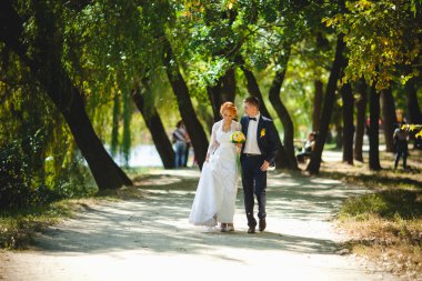 Mavi takım elbiseli, beyaz elbiseli ve buketli güzel bir çift.