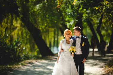 Mavi takım elbiseli, beyaz elbiseli ve buketli güzel bir çift.