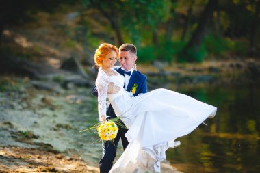 Mavi takım elbiseli, beyaz elbiseli ve buketli güzel bir çift.