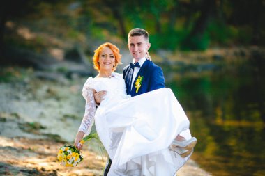 Mavi takım elbiseli, beyaz elbiseli ve buketli güzel bir çift.