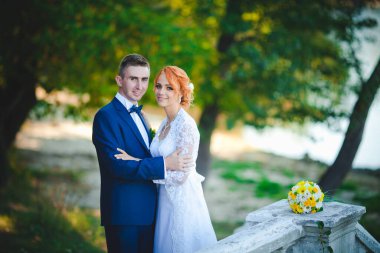 Mavi takım elbiseli, beyaz elbiseli ve buketli güzel bir çift.