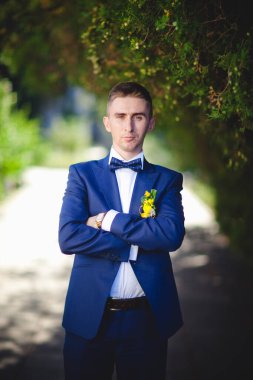 Mavi takım elbiseli, beyaz elbiseli ve buketli güzel bir çift.