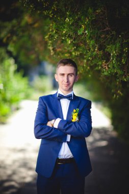 Mavi takım elbiseli, beyaz elbiseli ve buketli güzel bir çift.