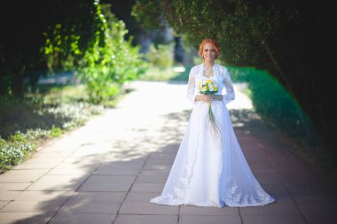 Mavi takım elbiseli, beyaz elbiseli ve buketli güzel bir çift.