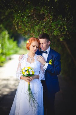 Mavi takım elbiseli, beyaz elbiseli ve buketli güzel bir çift.