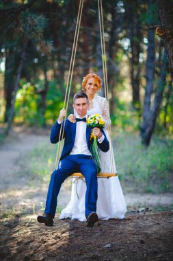 Mavi takım elbiseli, beyaz elbiseli ve buketli güzel bir çift.